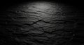 Dark, cracked surface texture resembling dry, arid ground. The light source is above, creating Royalty Free Stock Photo