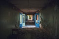 Dark creepy corridor with doors and broken floor in old scary abandoned building, tunnel view