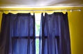 Dark curtains on the window in the room with yellow walls. Royalty Free Stock Photo