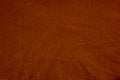 Dark deep burnt orange red brown terracotta texture background. Wrinkled crumpled natural cotton fabric cloth. Color.