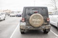 Dark dirty off road jeep parked in parking lot with wheel cover reading All Who Wander are Not Lost - Life