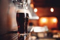 Dark Draft cold beer pour in glass from crane in pub Royalty Free Stock Photo