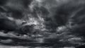 dark dramatic sky with black stormy clouds before rain or snow as abstract background, extreme weather, the sun shines through the