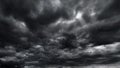 dark dramatic sky with black stormy clouds before rain or snow as abstract background, extreme weather, the sun shines through the Royalty Free Stock Photo