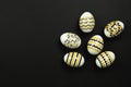 Dark Easter card with copy space for text. Easter golden decorated eggs with stripes and dots - flat lay, copy space. Royalty Free Stock Photo