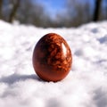 Dark Easter egg is lying on the snow. Royalty Free Stock Photo
