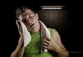 Dark edgy portrait of young sweaty tired and exhausted sport man with water bottle cooling off after hard fitness workout at gym