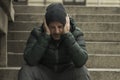 Dark and edgy urban portrait of middle aged sad and depressed unemployed man sitting outdoors on dirty street corner staircase Royalty Free Stock Photo