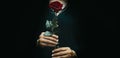 Dark effect of closeup Arabic woman  wearing moroccan abaya and holding beautiful red rose flower Royalty Free Stock Photo