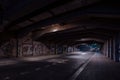Dark empty dirty grunge underground concrete tunel with a road during mystic night with blue street