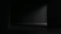 Dark empty studio room with a dramatic spotlight beam illuminating a small portion of the textured concrete floor and surrounding Royalty Free Stock Photo