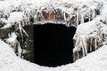 Dark Entrance to an Underground Cave Covered by Snow