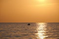 Dark figure of sportsman rowing alone on his kayak boat on sea water at sunset. Active extreme sports concept Royalty Free Stock Photo