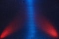 On a dark, finely grained background, central blue and lateral red rays of light Royalty Free Stock Photo
