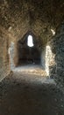Dark gallery under an ancient roman ruin with exposed stone and sun rays Royalty Free Stock Photo