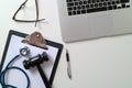 Dark Gavel With Medical Stethoscope near Laptop on white desk In Royalty Free Stock Photo