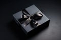 Dark gift box with satin ribbon and bow on black background. Holiday gift with copy space. Birthday or Christmas present, flat lay Royalty Free Stock Photo