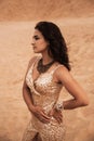 Dark girl with voluminous curly hair among the Sands in the sand dune Royalty Free Stock Photo