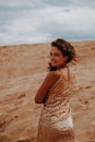 Dark girl with voluminous curly hair among the Sands in the sand dune Royalty Free Stock Photo