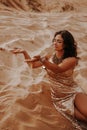 Dark girl with voluminous curly hair among the Sands in the sand dune Royalty Free Stock Photo