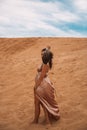 Dark girl with voluminous curly hair among the Sands in the sand dune Royalty Free Stock Photo