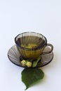 Dark glass cup with herbal hot linden tea with bloom flowers of linden Royalty Free Stock Photo