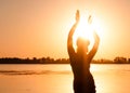 Silhouette of slim woman dancing traditional tribal belly dance on beach at sunrise Royalty Free Stock Photo