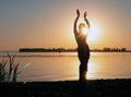 Silhouette of slim woman illuminated with sunshine dancing traditional tribal belly dance