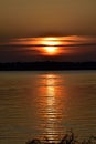 Dark gold lake sunset with the sun Partially hidden Royalty Free Stock Photo