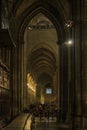 Dark gothic cloister with ornate arches the Notre Dame de Paris Cathedral with the stained glass windows along the back wall in