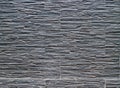 Dark gray cladding wall made of stoneware panels with stone effect