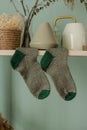 Dark gray and green knitted socks hanging on shelf Royalty Free Stock Photo