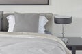 Dark gray pillow with comfy bed and black shade reading lamp Royalty Free Stock Photo