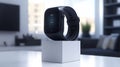 Dark gray smart watch on white cube, modern interior Royalty Free Stock Photo