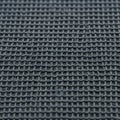 Dark gray waffle-knit fabric with a textured, grid-like pattern. The interlocking loops Royalty Free Stock Photo