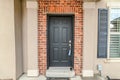 Dark gray wooden front door against red brick wall at the house entrance Royalty Free Stock Photo