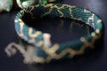 Dark green beaded necklace with golden print on a dark background Royalty Free Stock Photo
