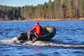 Dark green, inflatable rubber dinghy boat with motor, forest Lake.