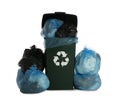 Dark green recycling bin overfilled with garbage bags on white background Royalty Free Stock Photo