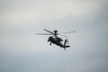 Dark grey army attack helicopter in flight during the daytime