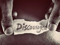 on the dark grey background the word discouraged written by hand