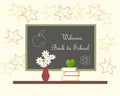 Dark grey blackboard with white lettering Welcome Back to School red vase with white flowers, green Apple on books