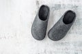 Dark grey felt wool home male winter pair slippers on stone floor background Royalty Free Stock Photo