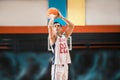 Dark-haired athletic man playing basket-ball in the gym