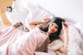 Dark haired beautiful young brunette wake up in her bed. Cheerful attractive woman lying on bed an posing on camera Royalty Free Stock Photo