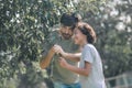 Dark-haired boy and his dad cutting branches in the garden