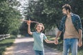 Dark-haired boy playing with a toy airplane, his father holding his hand Royalty Free Stock Photo