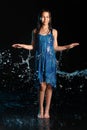 Dark-haired brown-eyed teenage girl posing in a black aqua-zone. Royalty Free Stock Photo