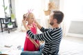 Dark-haired daddy giving pink crown to his little princess