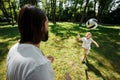 Dark-haired father and his little son dressed in the white t-shirts are playing football on a lawn on a warm day. Royalty Free Stock Photo